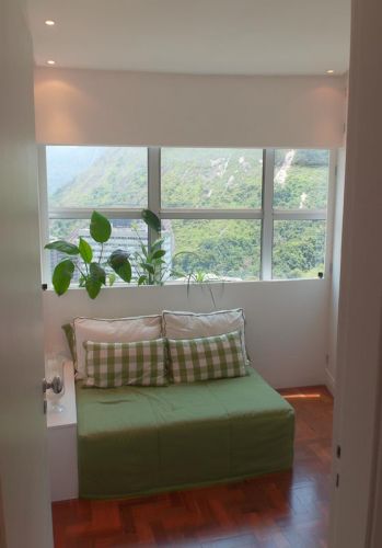 Um painel de MDF colocado junto à janela criou uma pequena jardineira, que serve de encosto para o futon