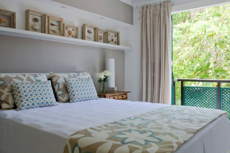 A atmosfera agradável do dormitório do casal se completa com o terraço, de onde se visualiza o verde do jardim