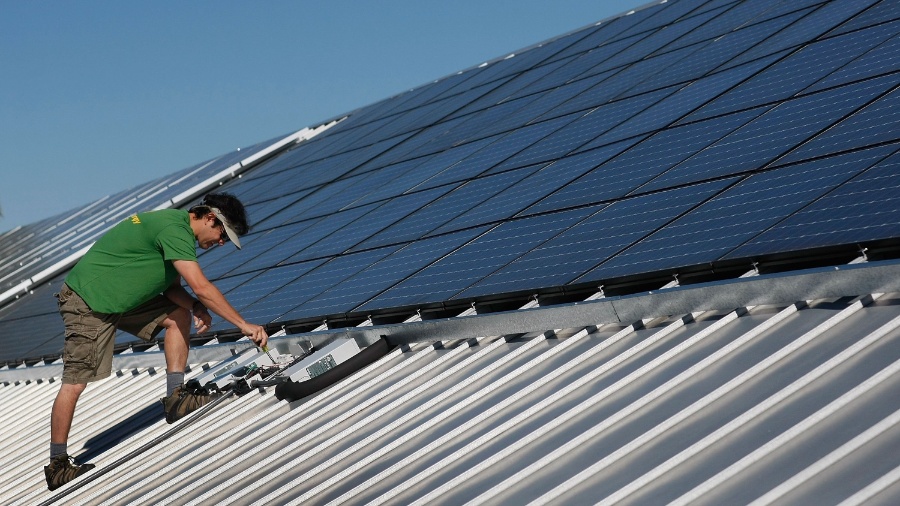 Funcionário da empresa Pure Energy Solar instala painéis fotovoltaicos em telhado de prédio comercial em Gainesville, na Flórida, EUA (15/04/2009) - Joe Raedle/Getty Images/AFP