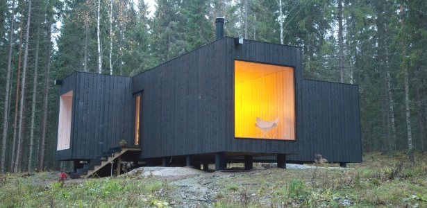 Casa na Finlândia tem acabamento "escuro" em concordância com a madeira dos pinheiros - Goeril Saetre/The New York Times